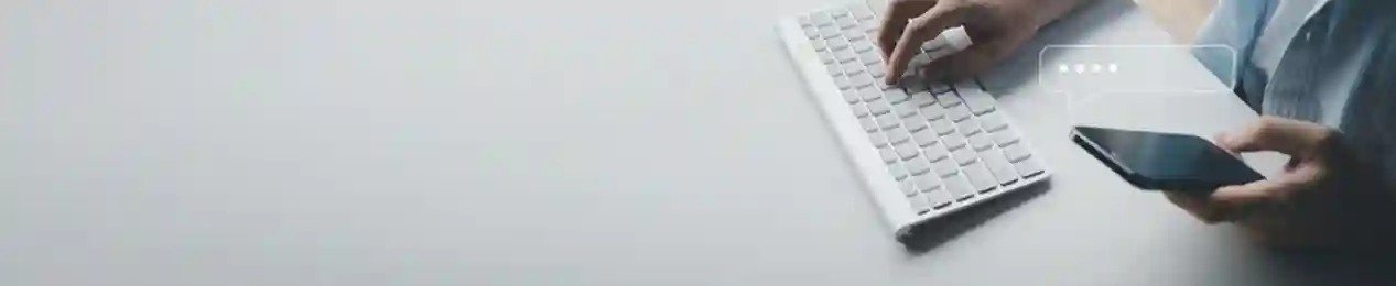 https://www.filemyrti.com/Person using phone and typing on laptop